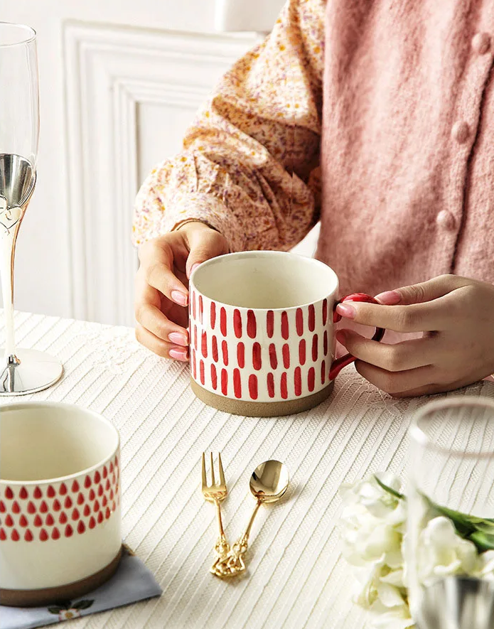 Woman Holding Red Seeds Grounded Art Ceramic Tea Cup With Red Rain Pattern Cup Also On Table