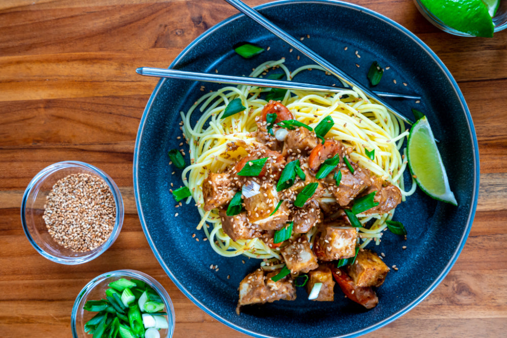 Delicious Sesame Noodles With Tofu And Almond Sauce Garnished With Toasted Bob's Red Mill White Sesame Seeds And Limes