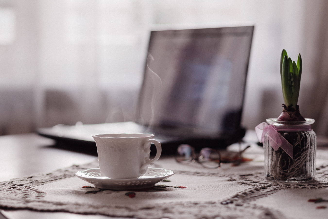 Cup And Saucer Of Steaming Hot Tea With Laptop