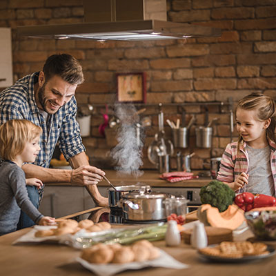 Father With Children Cooking Ralston Rice Together At Home In Brick Kitchen