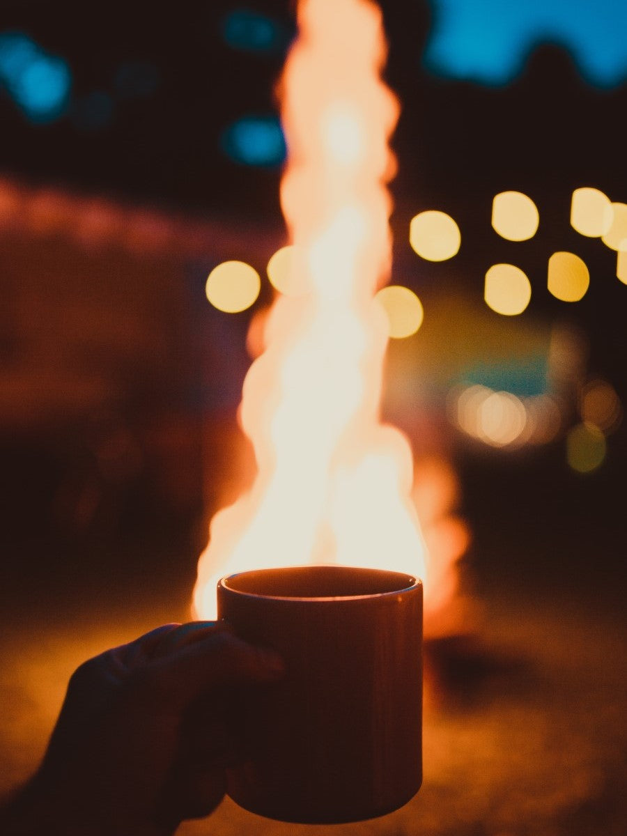 Holding Hot Mug Of Organic Witches Brew Blend X Coffee In Front Of Campfire