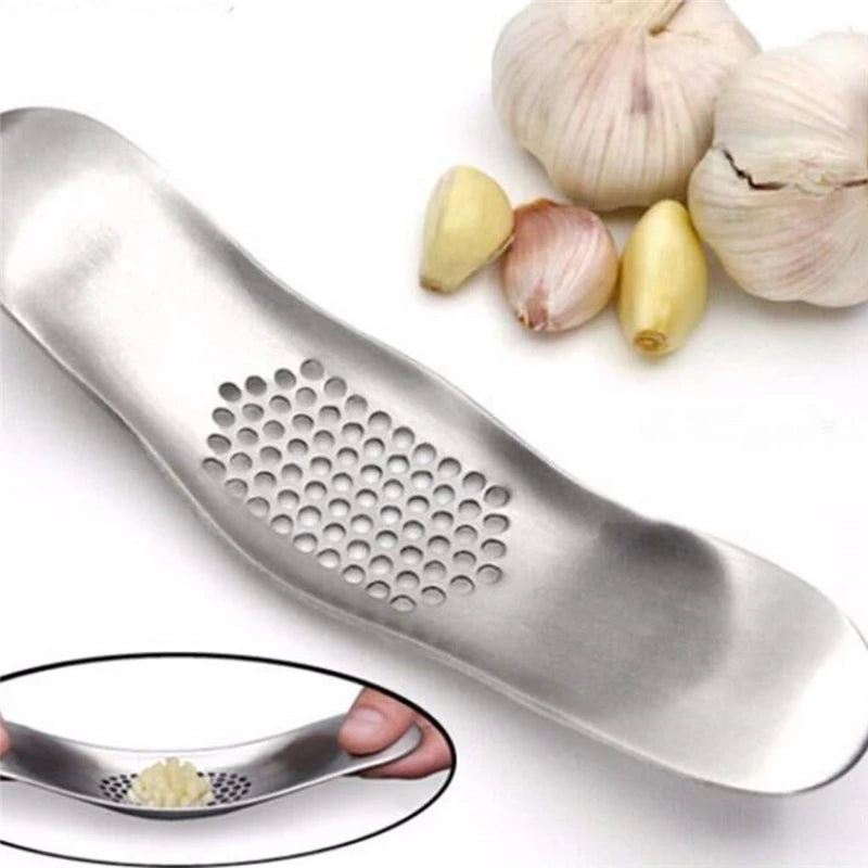 Close Up Of Stainless Steel Garlic Rocker Press With Fresh Garlic Cloves