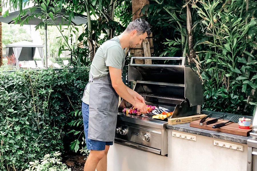 Man Outdoors Barbecuing In Backyard With If You Care Heavy Duty Recycled Aluminum Foil